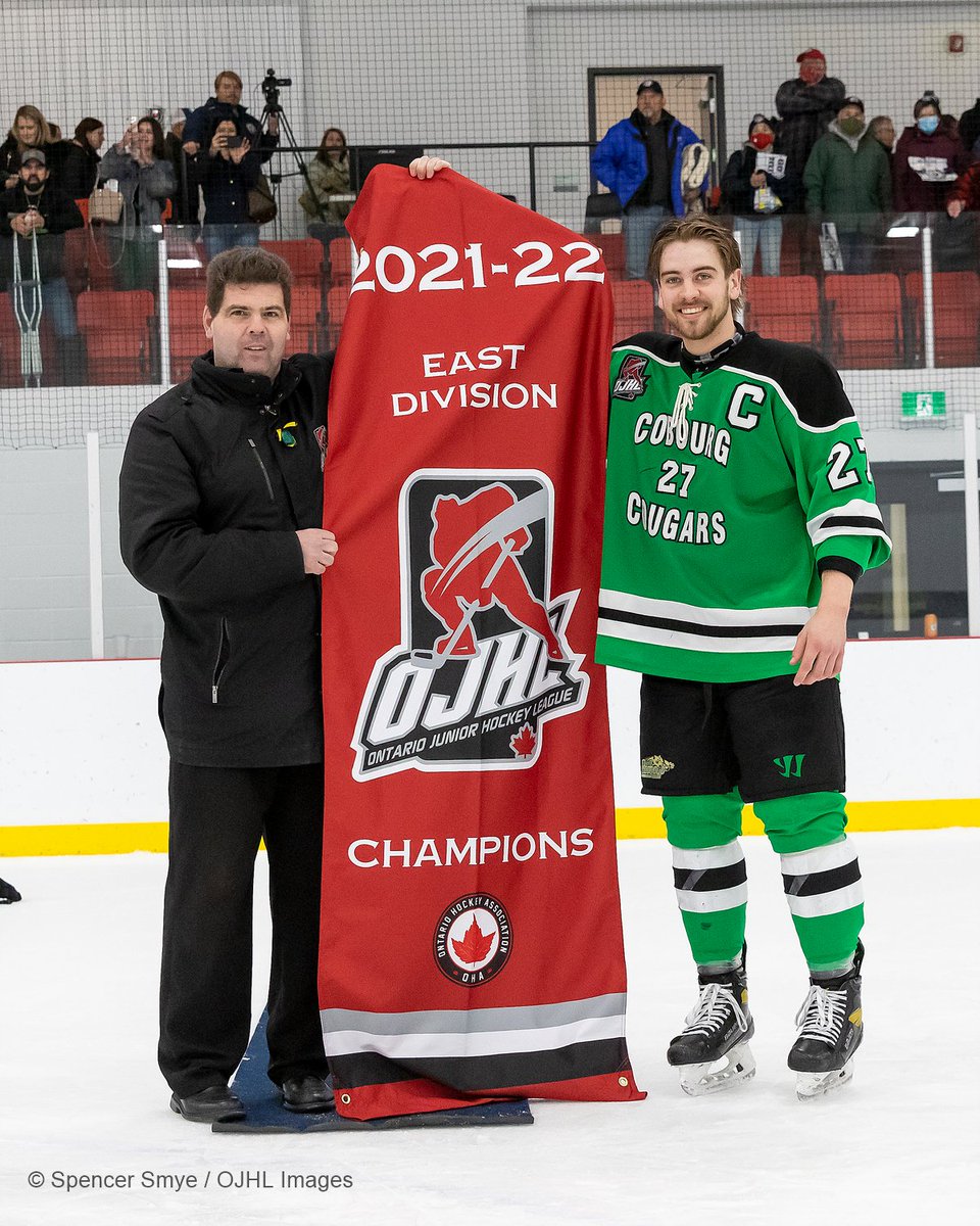 SmyePhotography's tweet image. OJHL executive Rob MacGregor presents captain Tucker Firth #27 of the Cobourg Cougars the 2021-22 East Division Champions banner #ojhlimages #ojhl #followthephotogs