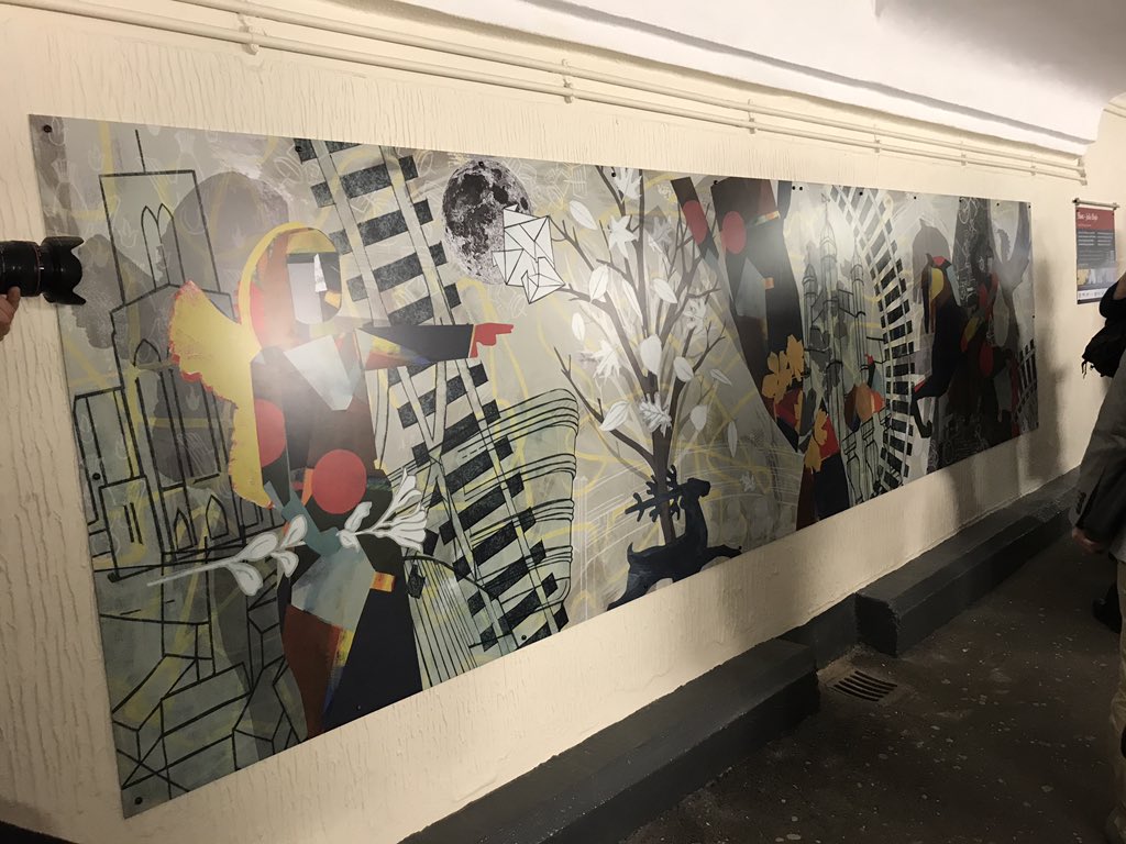 DanRailing's tweet photo. So this is what I’ve come to see - a brand new piece of public art for Guildford, “Host” by artist Julie Hoyle. It’s a huge mural, in two 5m-long sections, full of details about local history and features. https://t.co/KC5LLJU3to