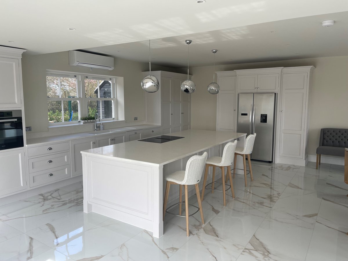 Cool and white bespoke John Ladbury kitchen with quartz composite work surface and porcelain floor tiles.  #croftandassinder #clearwater #johnladbury #bespokekitchen  #inductionhob #tomdixonmelt #whitekitchen #Hertfordshire #newkitchen #quartzworktop