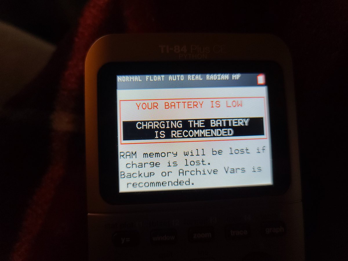 a TI-84 Plus CE Python displaying the following warning:
"YOUR BATTERY IS LOW
CHARGING THE BATTERY IS RECOMMENDED
RAM memory will be lost if charge is lost.
Backup or Archive Vars is recommended."