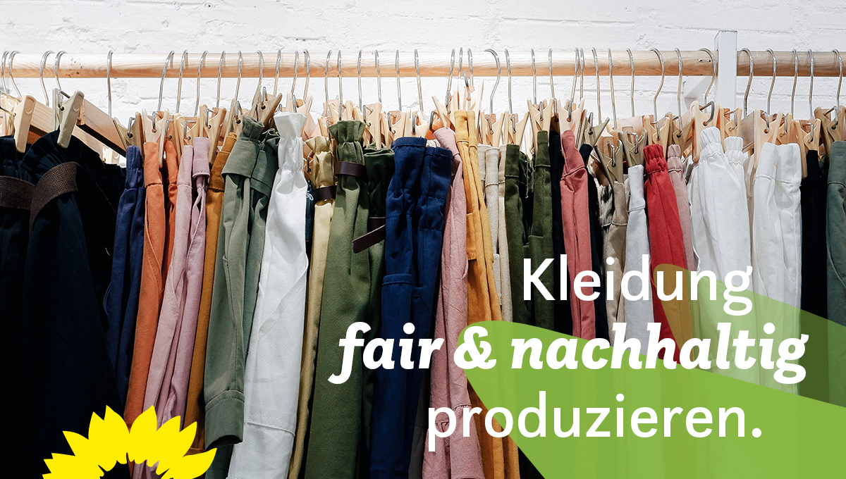 Auf dem Bild ist eine hölzerne Kleiderstange vor einer weißen Wand mit vielen Kleiderbügeln abgebildet. Es sind vorwiegend kurze und lange Hosen mit den Bügeln aufgehängt. In der rechten unteren Bildecke steht: Kleidung fair & nachhaltig produzieren. In der linken unteren Bildecke ist eine stilisierte Sonnenblume abgebildet. 