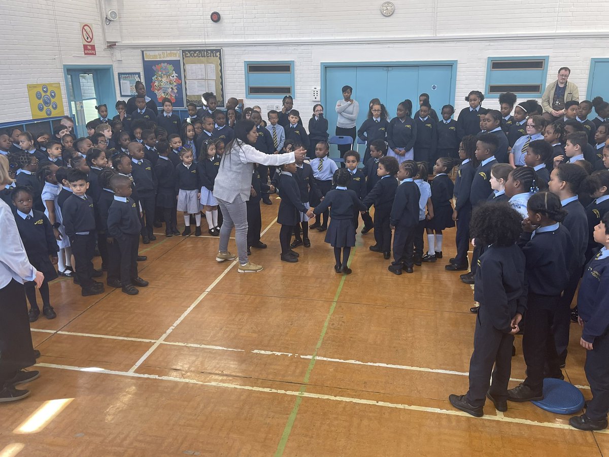 StAndrewsSW9's tweet photo. Miss Betty leading a powerful Praise Assembly on Love ❤️ The children worked collectively to join hands in a spiral starting from Reception to Year 6 sharing love. #praiseweek #SW9partnership #standrews https://t.co/2lxkikhmPS