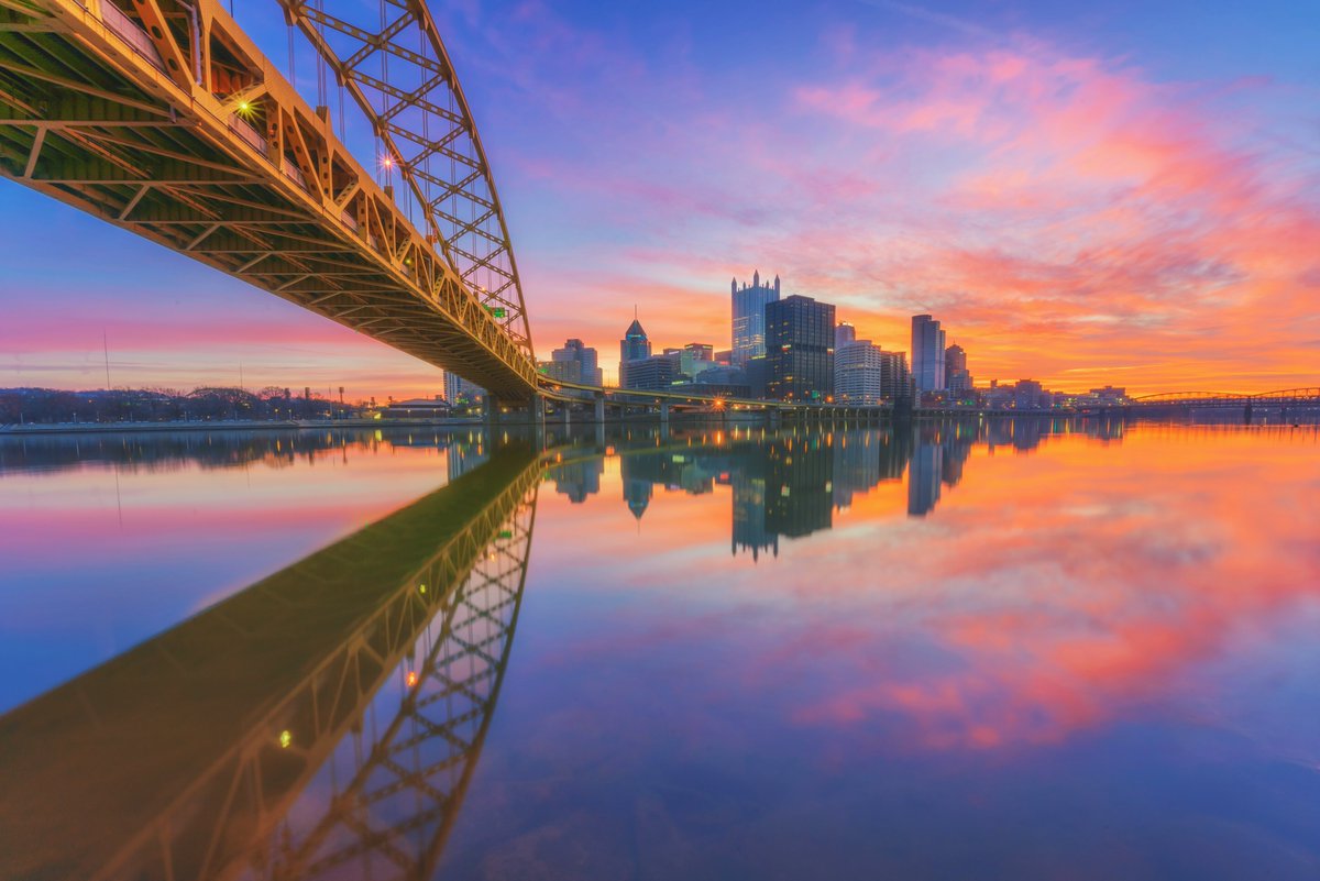DaveDiCello's tweet image. Every now and then the rivers in #Pittsburgh can be surprisingly clear, like this incredible morning under the Ft. Pitt Bridge. You can actually see rocks at the bottom of the river, as a colorful sunrise stretches out over the city and reflects in the calm Monongahela.
