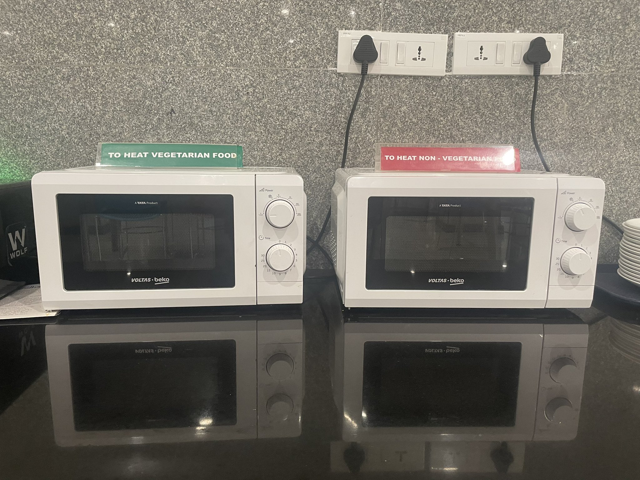Two identical microwaves, one labelled "To heat vegetarian food" and the other "To heat non-vegetarian food"