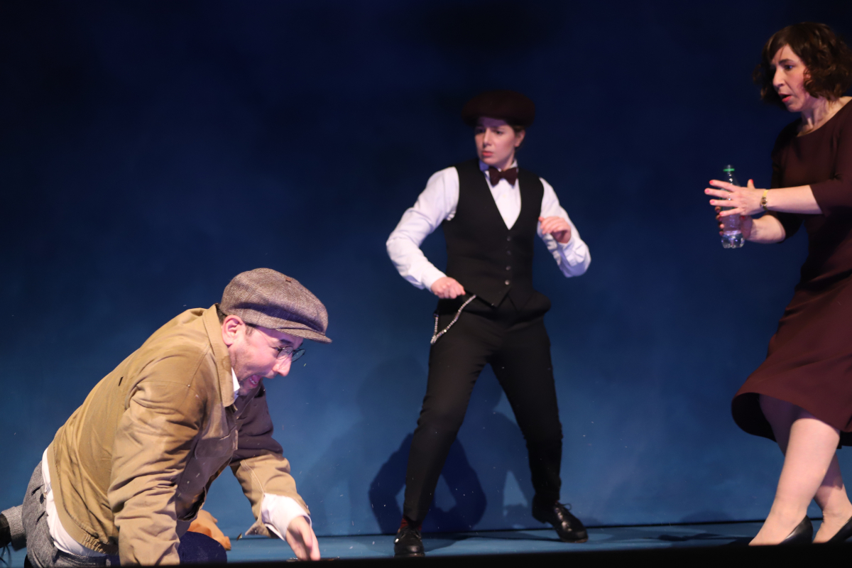 Das Bild zeigt Taner Şahintürk als sterbenden Lieferando-Fahrer vor den snobbischen Kundinnen (Aysima Ergün und Orit Nahmias). In der Komödie "Rabatt" von Nora Abdel-Maksoud am Berliner Maxim Gorki Theater © Lutz Knospe