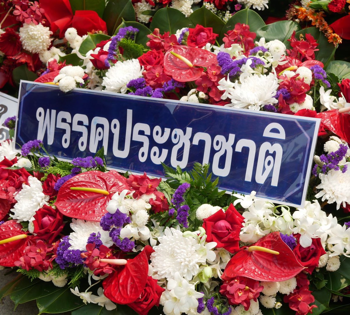 PNSNTK's tweet photo. พวงหรีดพรรคประชาชาติกับของลูกนัทก็มีสีม่วงนะ https://t.co/aL2d2ANaiT