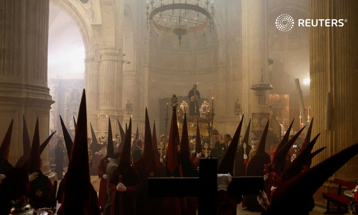 Penitents belonging to Los Gitanos brotherhood wait inside a church to take part in a Palm Sunday pr...