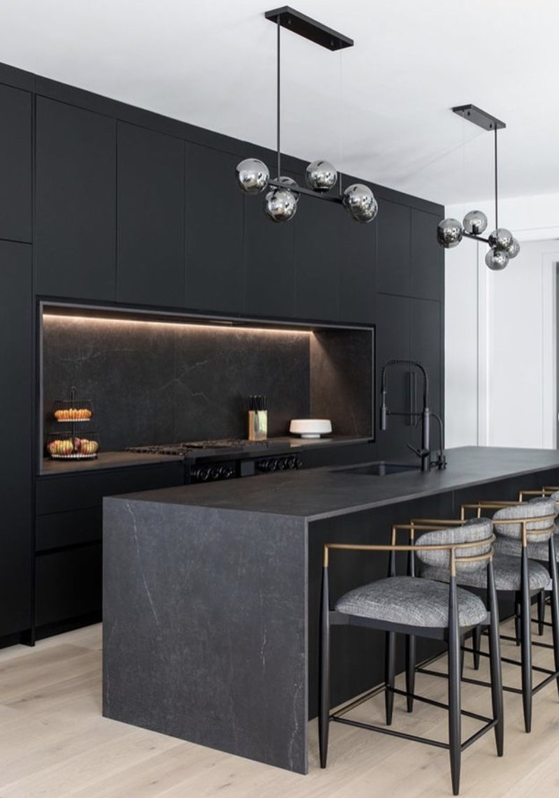 This kitchen by @kuchecucina oozes luxury with its dark colour palette. Featured on a waterfall island and backlit splashback, Dekton Laos has helped to bring together this sophisticated kitchen while offering superior resistance to scratches & stains 📷bit.ly/raquellangwort…