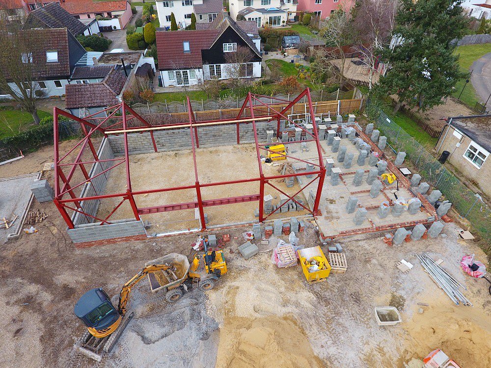 LignaciteUK's tweet photo. Great to see the progress being made on the new village hall at Tuddenham St Mary in #Suffolk!

The foundations are in, the steel frame is in place, and the blockwork is going up in earnest.

Thanks to developer, Mill House Homes for this superb aerial snap. 📸 

#construction https://t.co/yXgZP7aarY