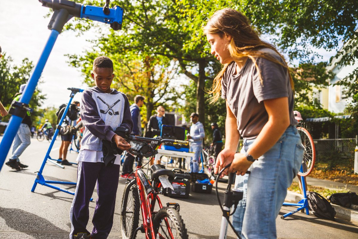 two young people inflate a bicycle tire