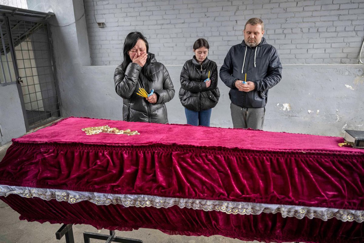 WHY?
Olena Dereko and her family surround the coffin of her daughter (23) following the ‘horrific’ death at the hands of Russian torturers
⁠'Inside that coffin,draped in a reddish pink velvet with a gold and white lace trim, were the mutilated remains of their tenacious daughter