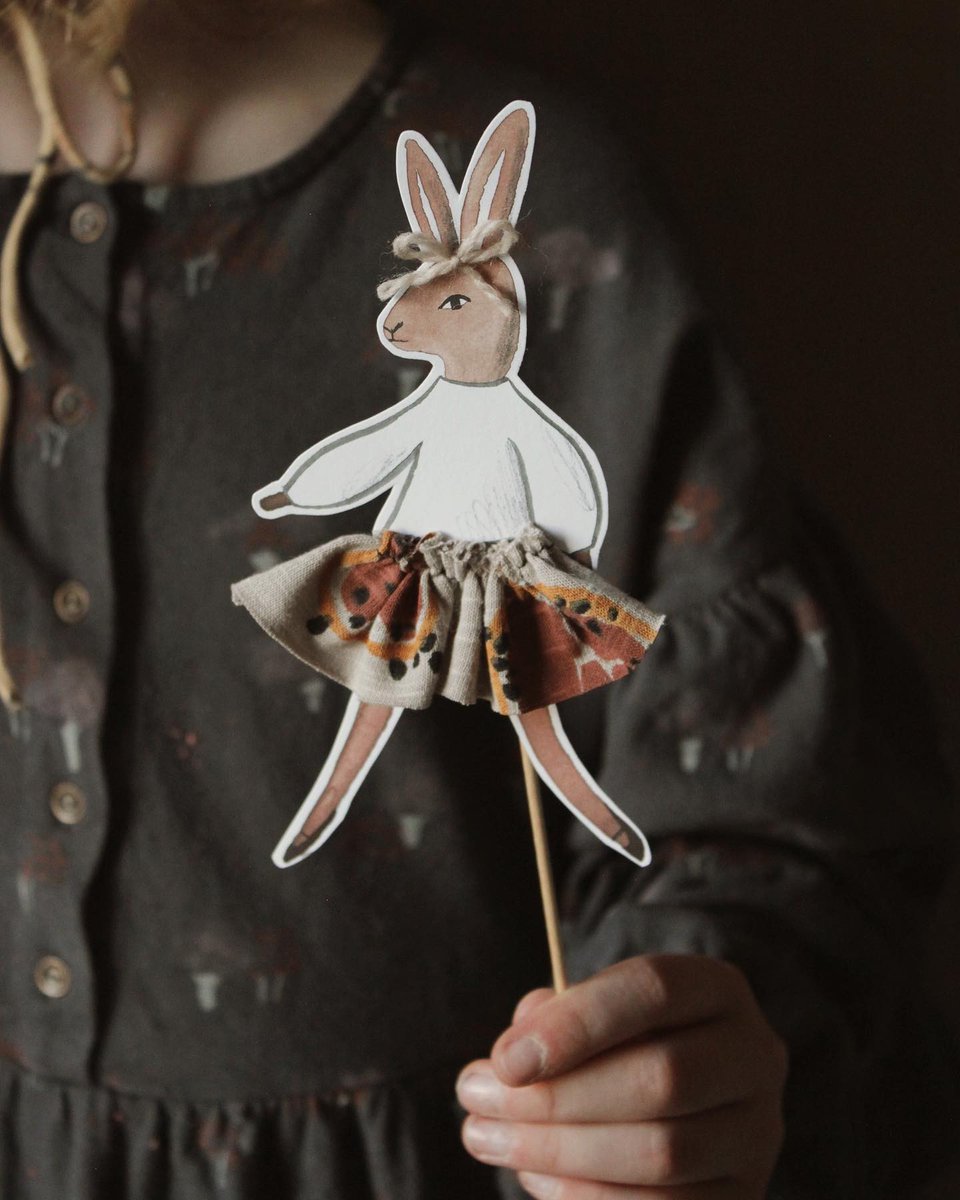 A person holding a cutout of an Easter bunny paper figure.