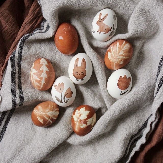 A few painted eggs in pastel colors laid out on a towel, photographed from above.