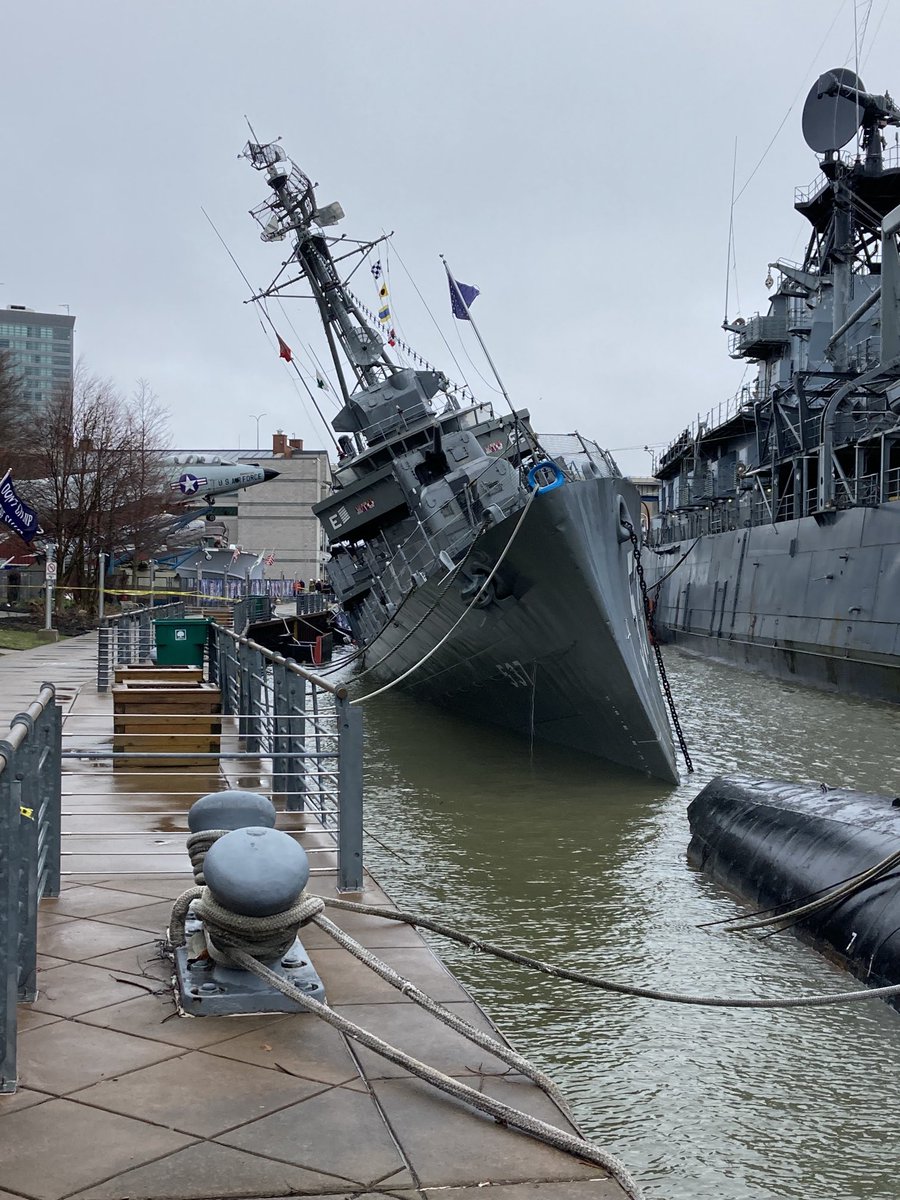RonWGRZ's tweet image. This gives a better perspective of the list angle of USS The Sullivan’s. Salvage crews trying to figure out some way to pump water but difficult situation to right this ship. Very thin hull may have been punctured near stern (back) of ship.⁦@WGRZ⁩