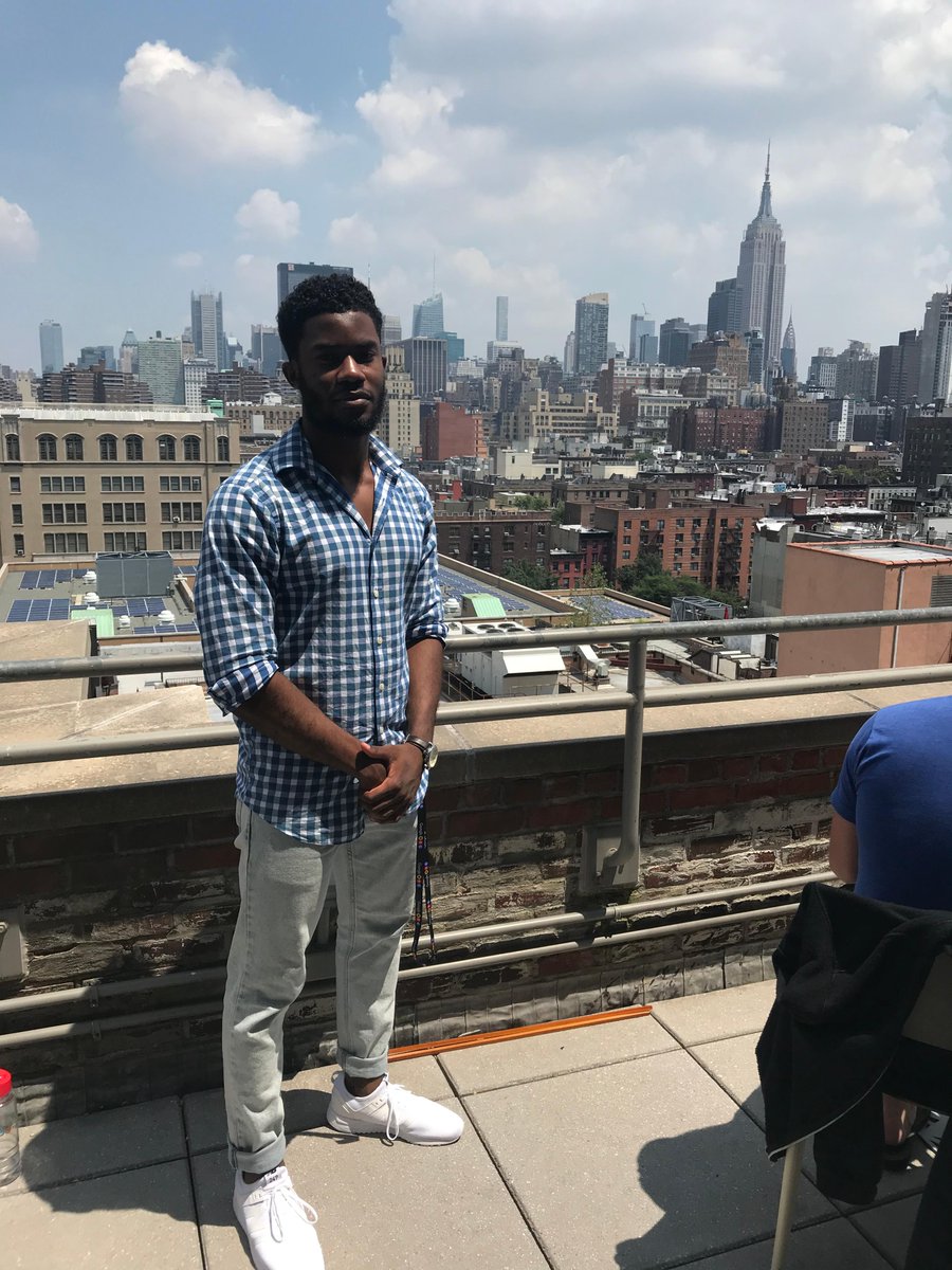 Randy on a rooftop with the New York city skyline behind him.
