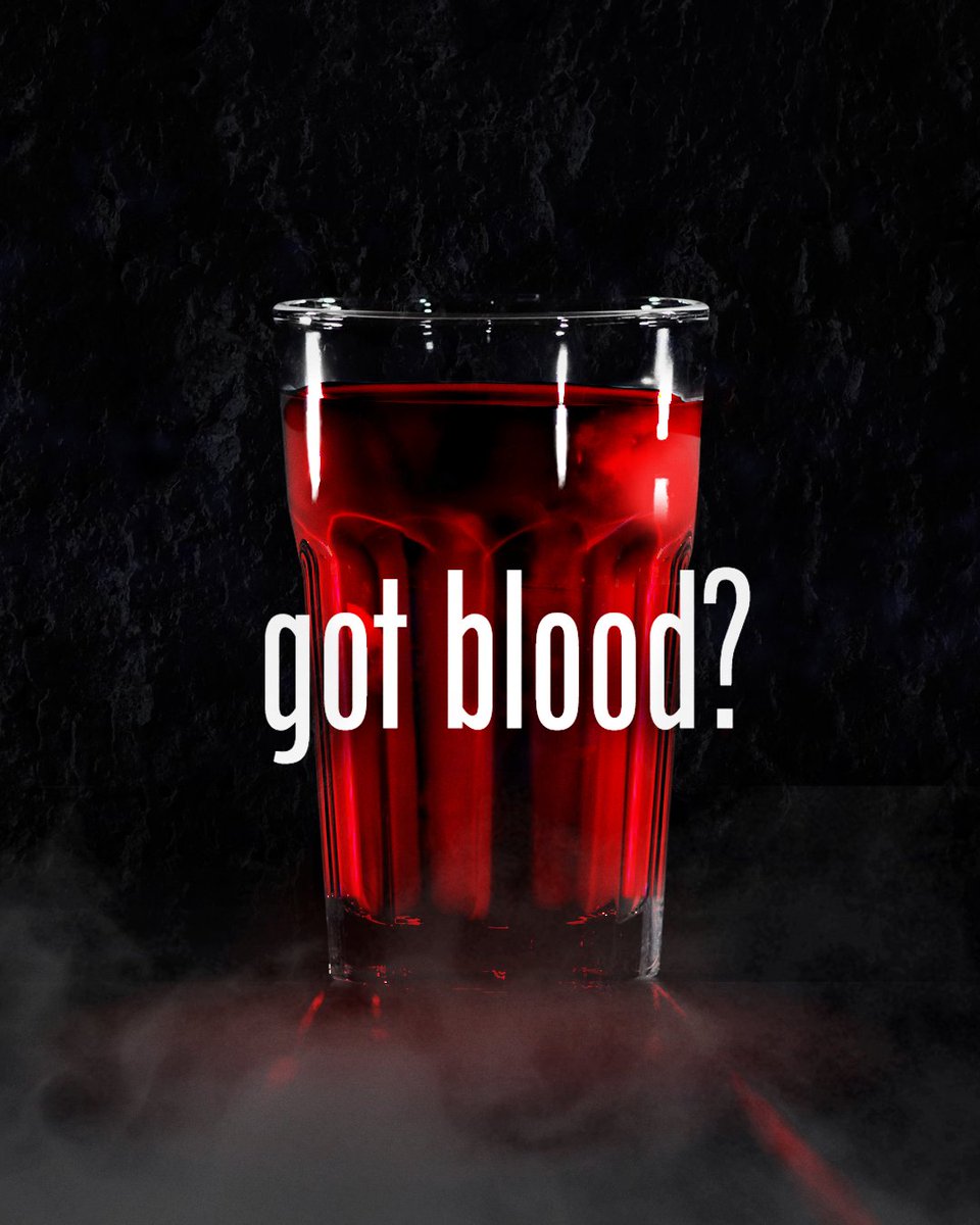 Image shows a large glass filled with blood against a black backdrop with a layer of fog sitting below the glass. 