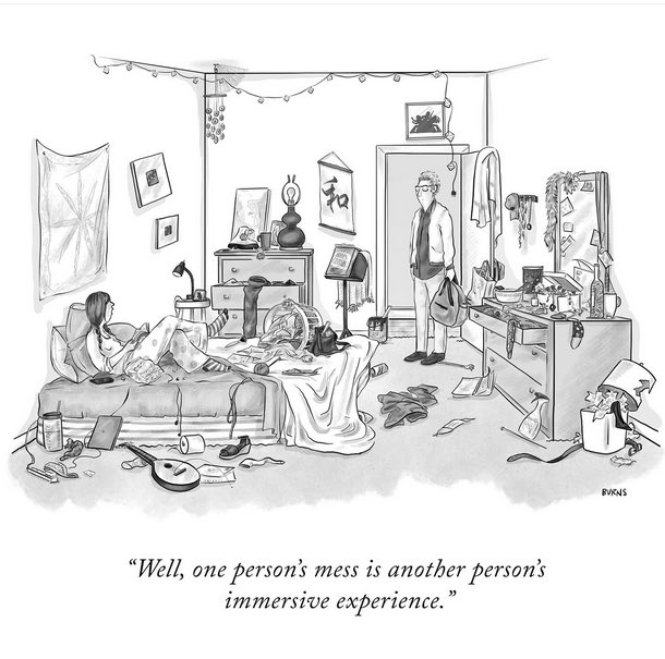 Cartoon of a person in bed in a very messy bedroom speaking to another person standing in an open doorway. “Well, one person’s mess is another person’s immersive experience.”