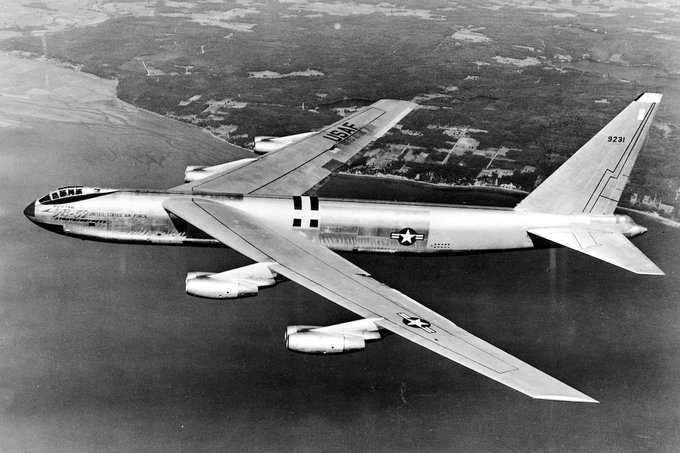 Large aircraft in flight over water close to the coast.