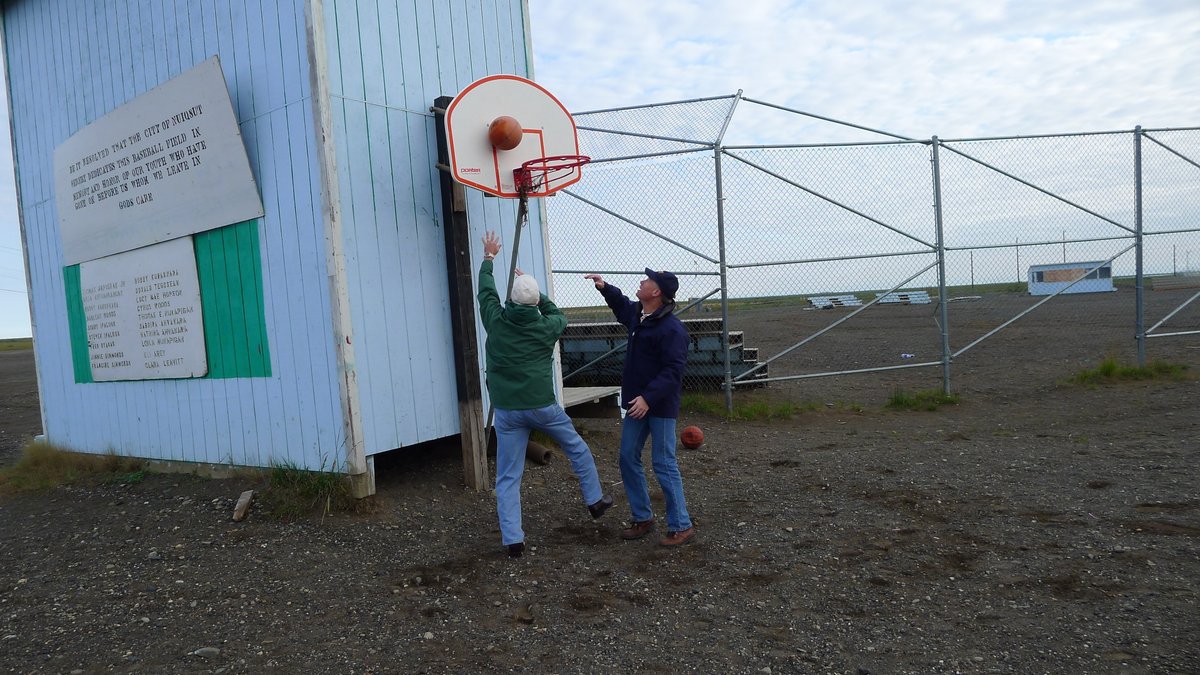 ANC_Historian's tweet photo. Aug 12, 2012, Ken Salazar (green coat), Secretary of Interior under President Obama, playing basketball against unidentified man at Nuiqsut. Via National Archives #alaskahistory #nuiqsut https://t.co/Kkx0Yn42im