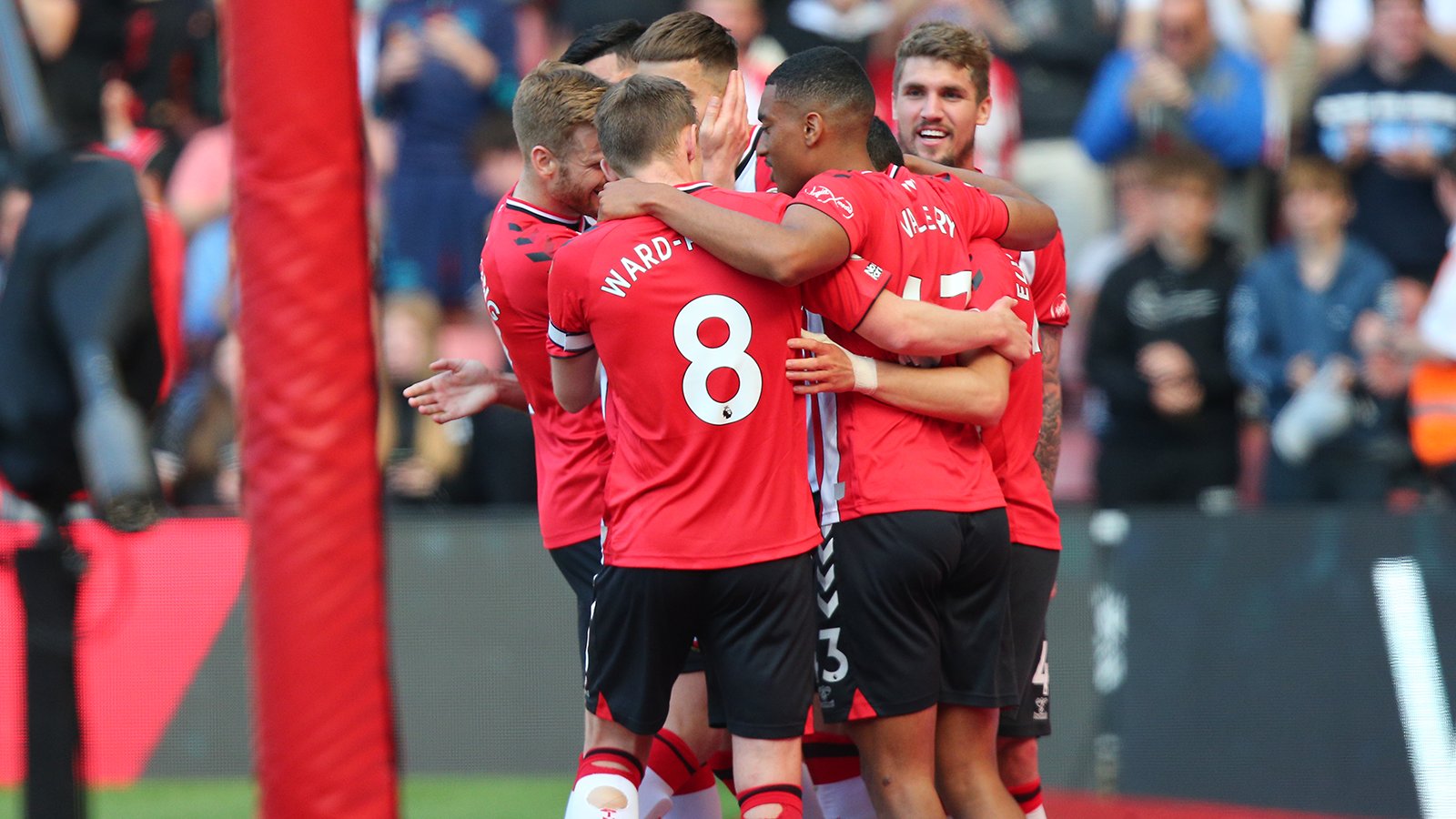 Jan Bednarek is hugged by a group of Saints teammates after scoring against Arsenal.