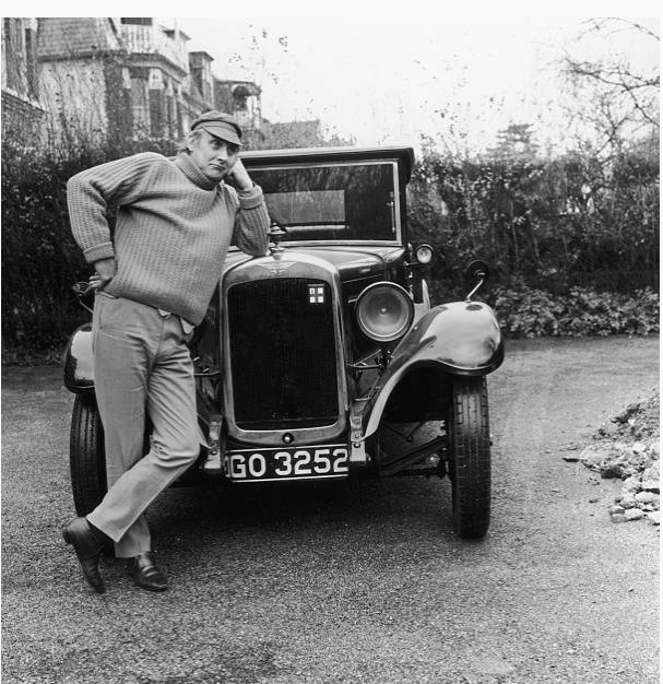 Spike Milligan leaning on his Austin 7 📷 Aubrey Hart, 1968