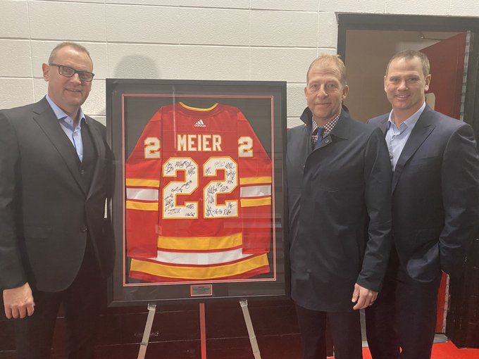 Brad Treliving and Craig Conroy present Brad Meier with signed jersey