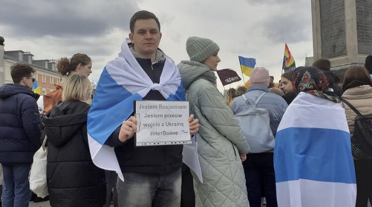 一名居住在波蘭華沙的俄羅斯移民在與數百名烏克蘭人一起參加反入侵抗議活動時，身著俄羅斯新的白藍白國旗。