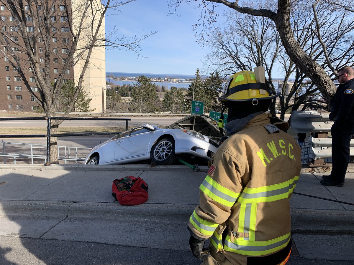 Duluth Fire is responding to the report of a car that rolled backward and is now hanging from a divider above Mesaba Avenue and West 1st Street. No one was injured. The car is totaled.