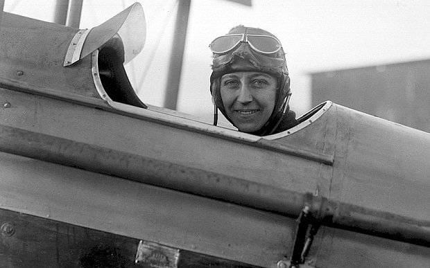 Amy Johnson CBE sitting in the cockpit of an aircraft.