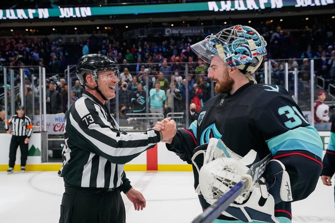 image of nhl linesman Vaughan Rody & Kraken goalie Philipp Grubauer embracing after Wednesdays night game at Climate Arena. 