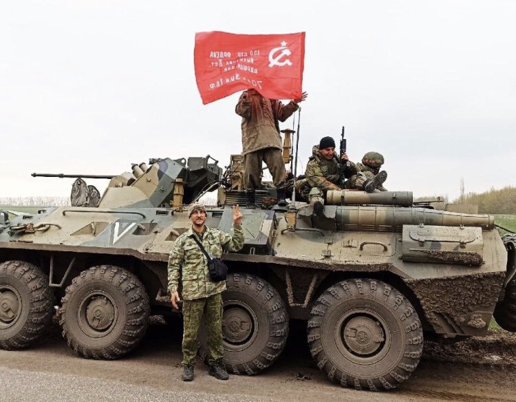 ソ連国旗を掲げて進む ロシア軍戦車と パーキンソン病かと疑われるような震えを見せるロシア連邦大統領プーチンの動画 プーチン大統領病気説 マイクロストック 投稿型ストックフォト または投稿型素材写真サイトの話