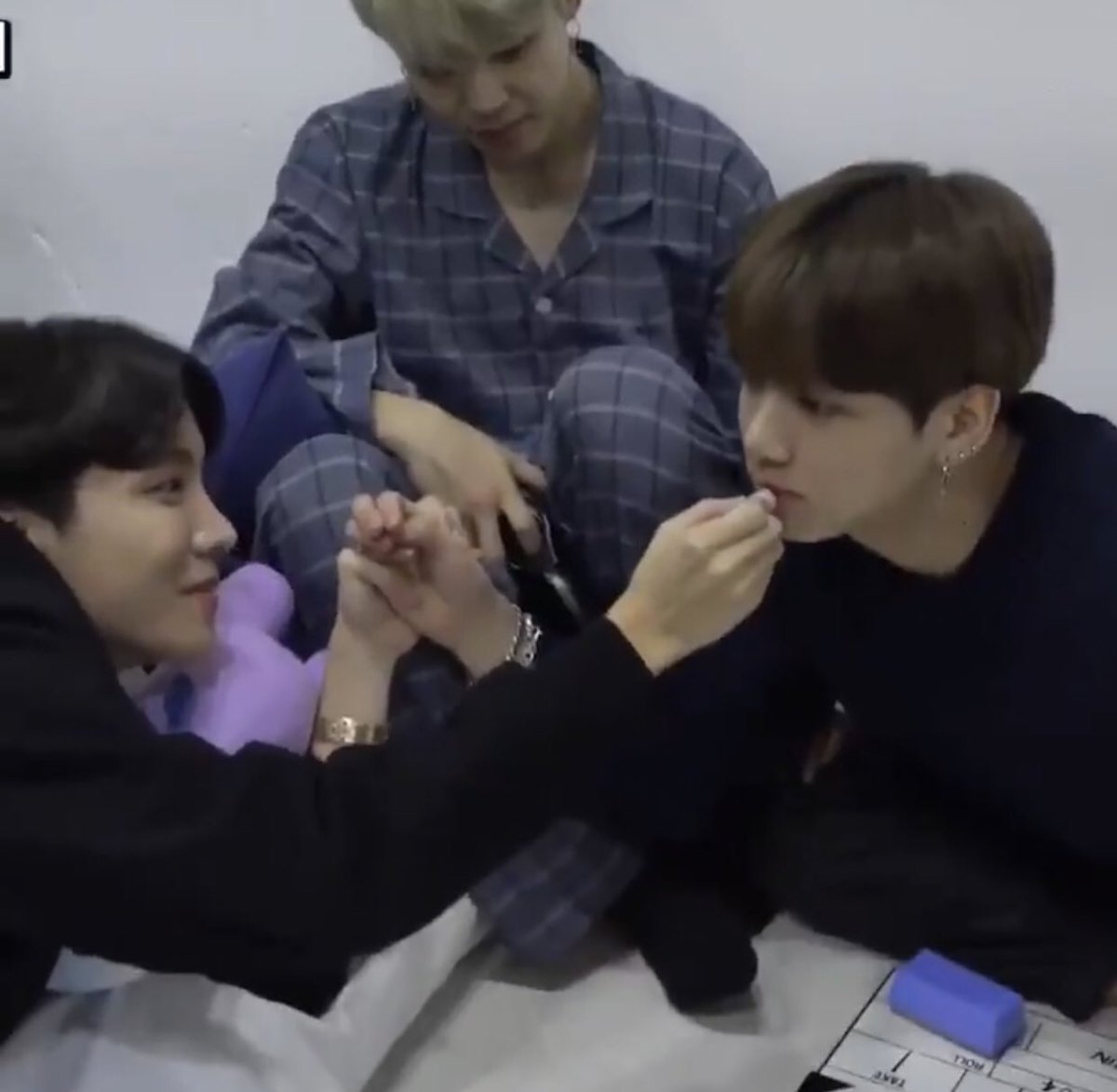 randomjungkook's tweet photo. jungkook’s hand held by hobi who is applying lip balm on him https://t.co/VSk9KA10s2