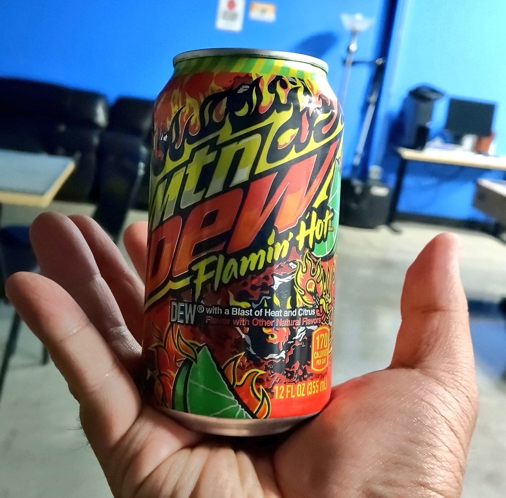 Photo of hand holding Flamin' Hot Mountain Dew.