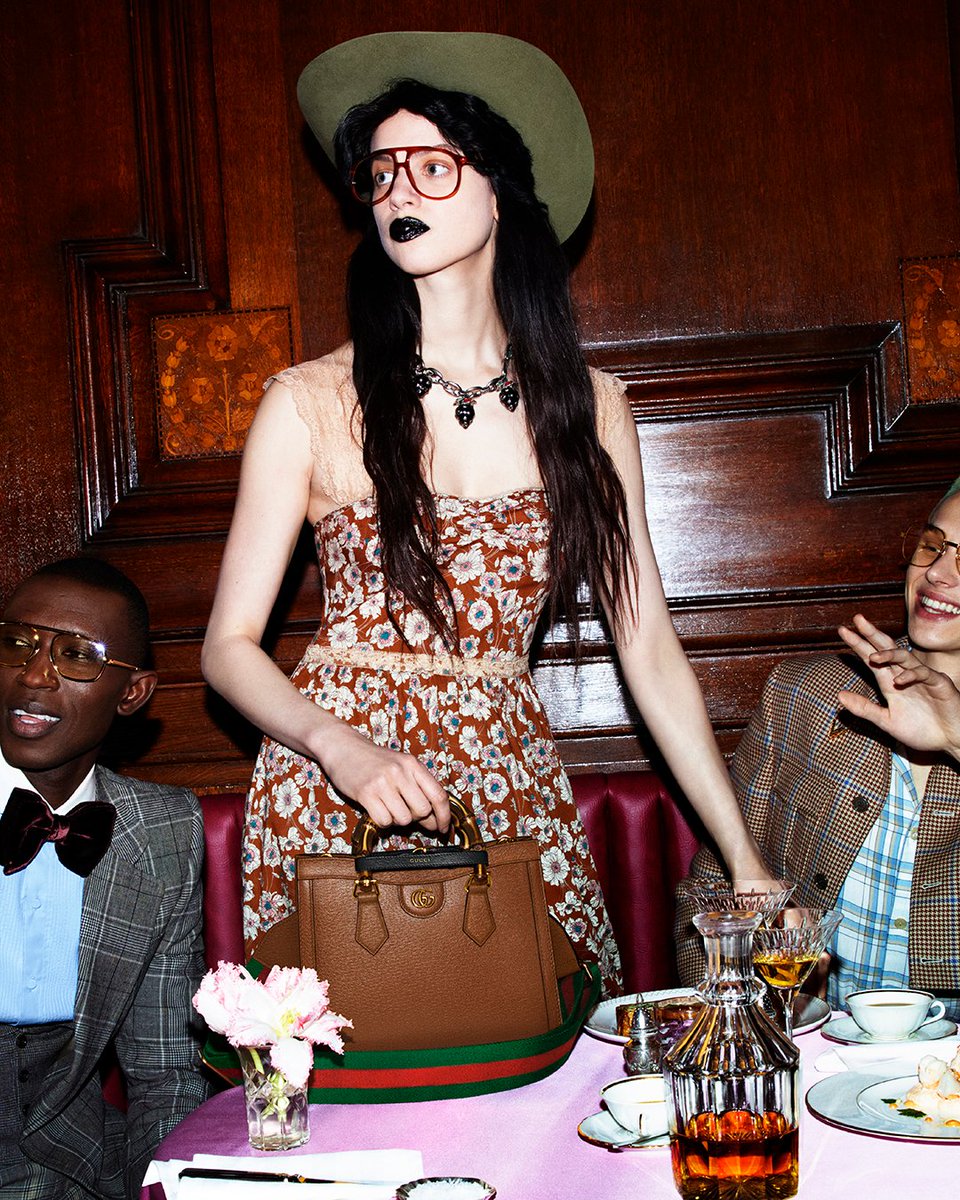 Captured within the convivial setting of a banquet, the #GucciDiana from the #GucciBeloved lines is seen with its bamboo top handles marked by leather belts, as well as a red and green Web strap. Discover more on.gucci.com/_GucciLovePara… #AlessandroMichele