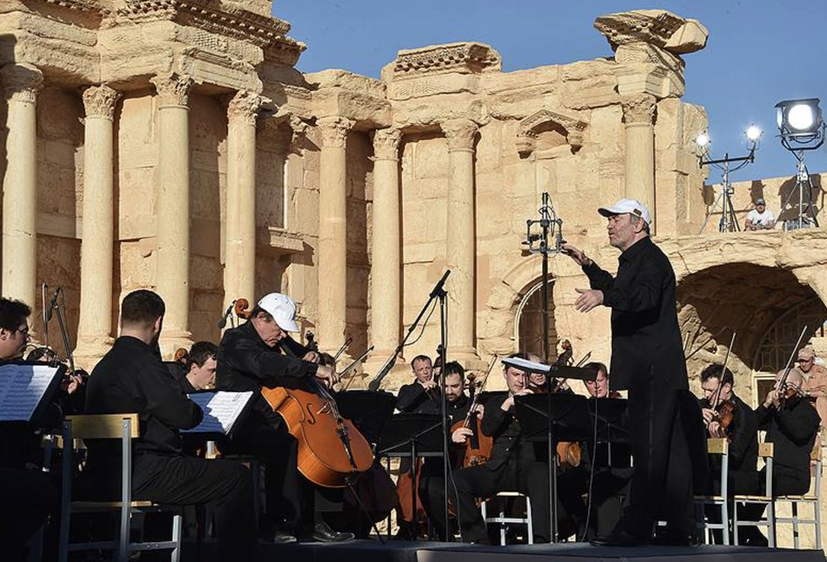 Here is Gergiev in Palmyra, Syria, performing for the Russian troops. Putin is watching.