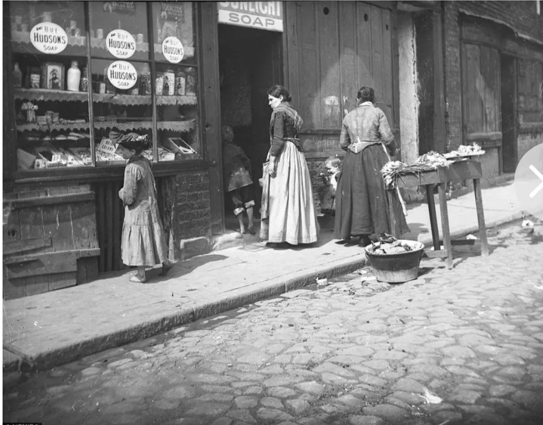 janeyellene's tweet photo. A young girl examines the window display in a shop in what was then the middle of Newcastle around 1890 https://t.co/5DKFSpoFIR