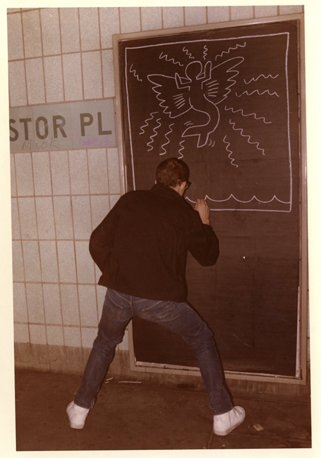 Keith Haring drawing on the wall of a downtown Manhattan subway station. ©KEITH HARING FOUNDATION. PHOTO: ELINOR VERNHES.