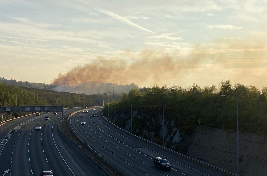 DubFireBrigade's tweet photo. Smoke is drifting from the Dublin mountains gorse wildfire but visibility is not affected at present on @M50Dublin . 

🪟 Do close windows if you are downwind of the fire and can smell smoke https://t.co/ak2jv96loU