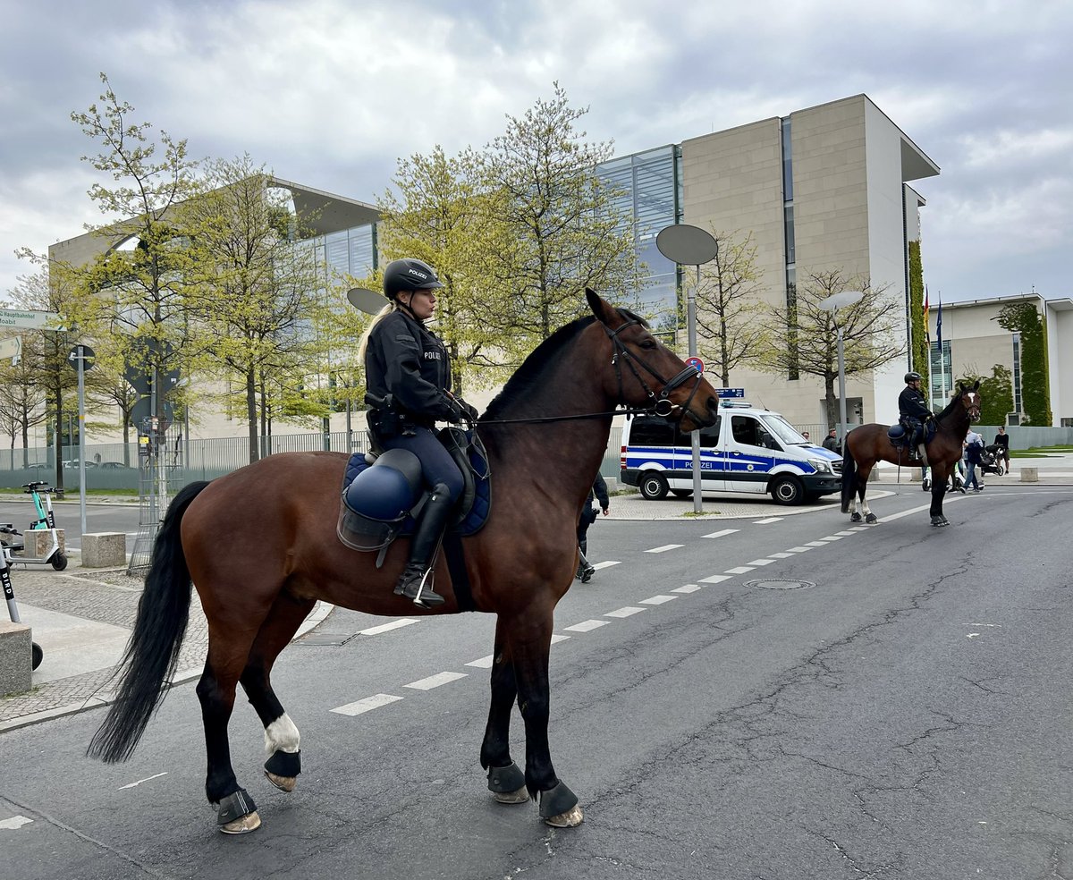 Zwei Polizeipferde mit Reiterinnen vor Bundeskanzleramt.