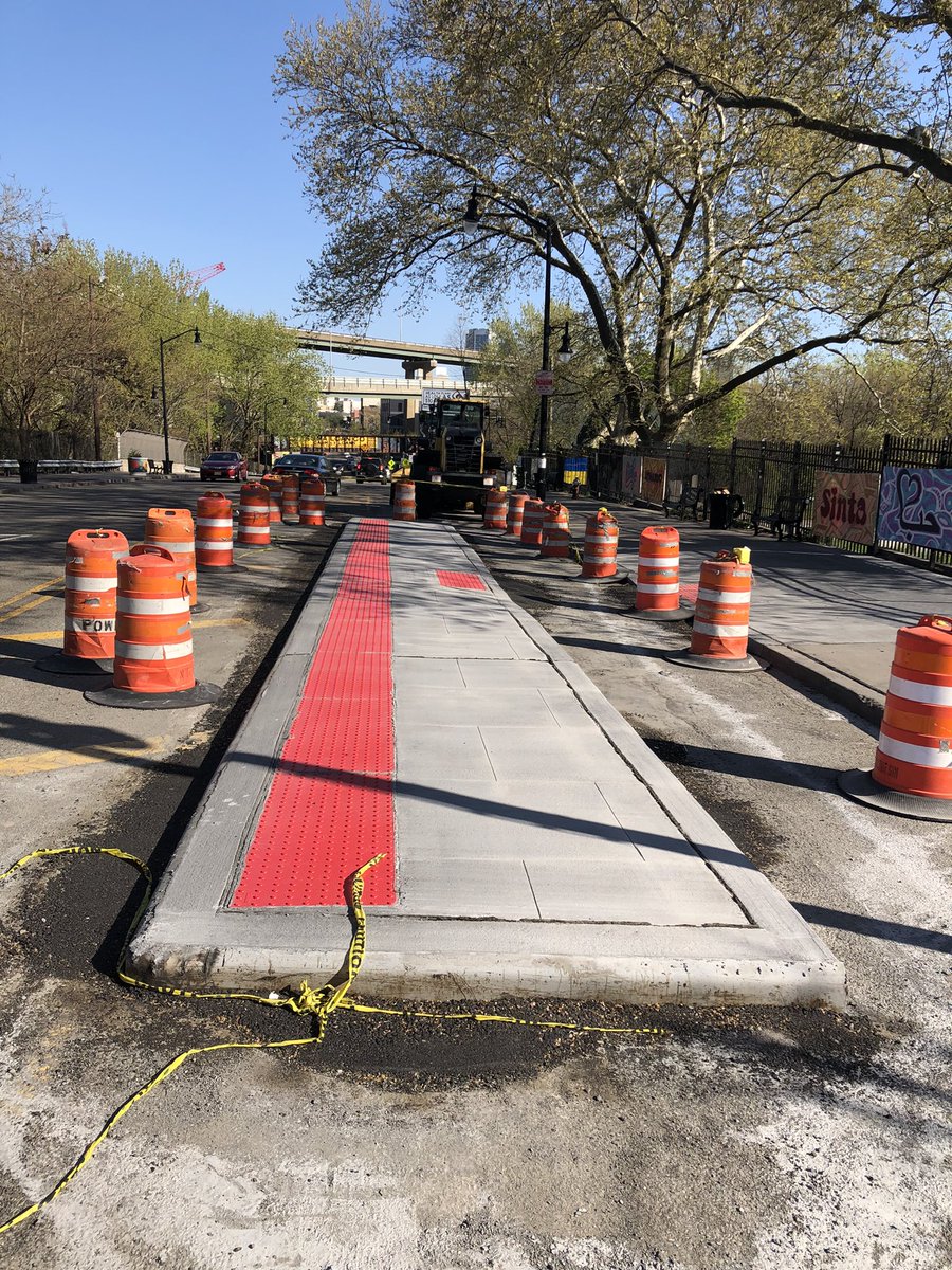 bikejc's tweet photo. A bit of street design history for Jersey City: First “floating bus stop” in JC getting built on the Newark Avenue hill past the cemetery. The channel at right is for a protected bike lane, preventing curbside conflicts with buses and further separating bikes from moving cars. https://t.co/PORf5vSTy1