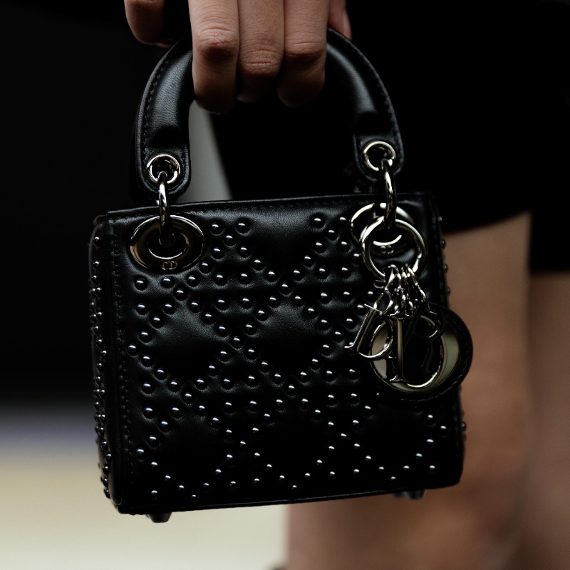 Dior's tweet photo. The edgy attitude of Fall 2022 by Maria Grazia Chiuri extends to even the micro-format Lady Dior bag whose characteristic Cannage quilting is reconfigured with studs, as seen backstage at the show in Seoul. Tap the image to explore the collection.
#DiorFall22