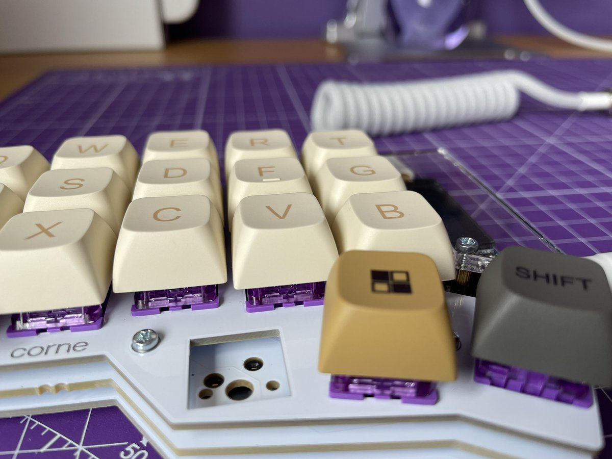 Front view of rebuilt keyboard, showing keycaps and purple switches visible beneath.