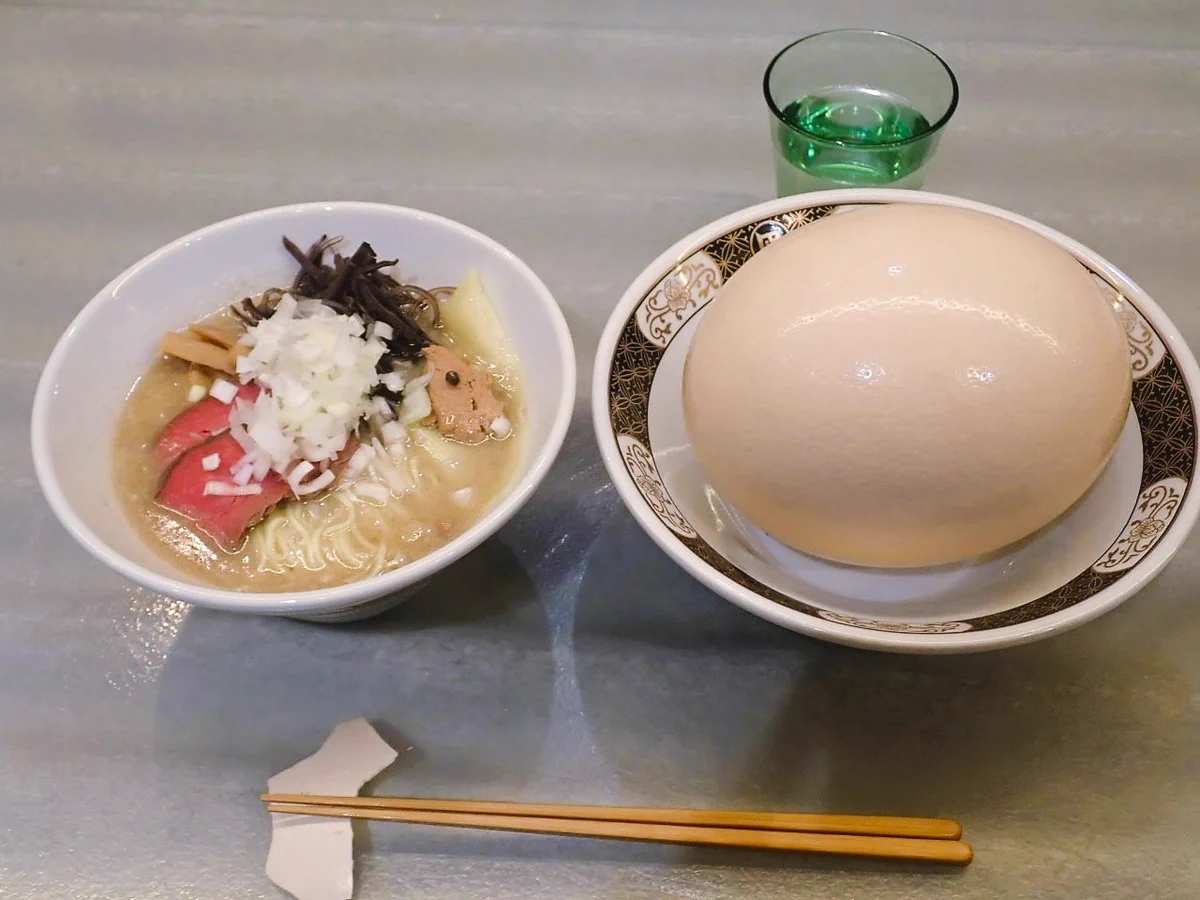 ラーメンの隣にある煮卵。サイズがおかしすぎる。