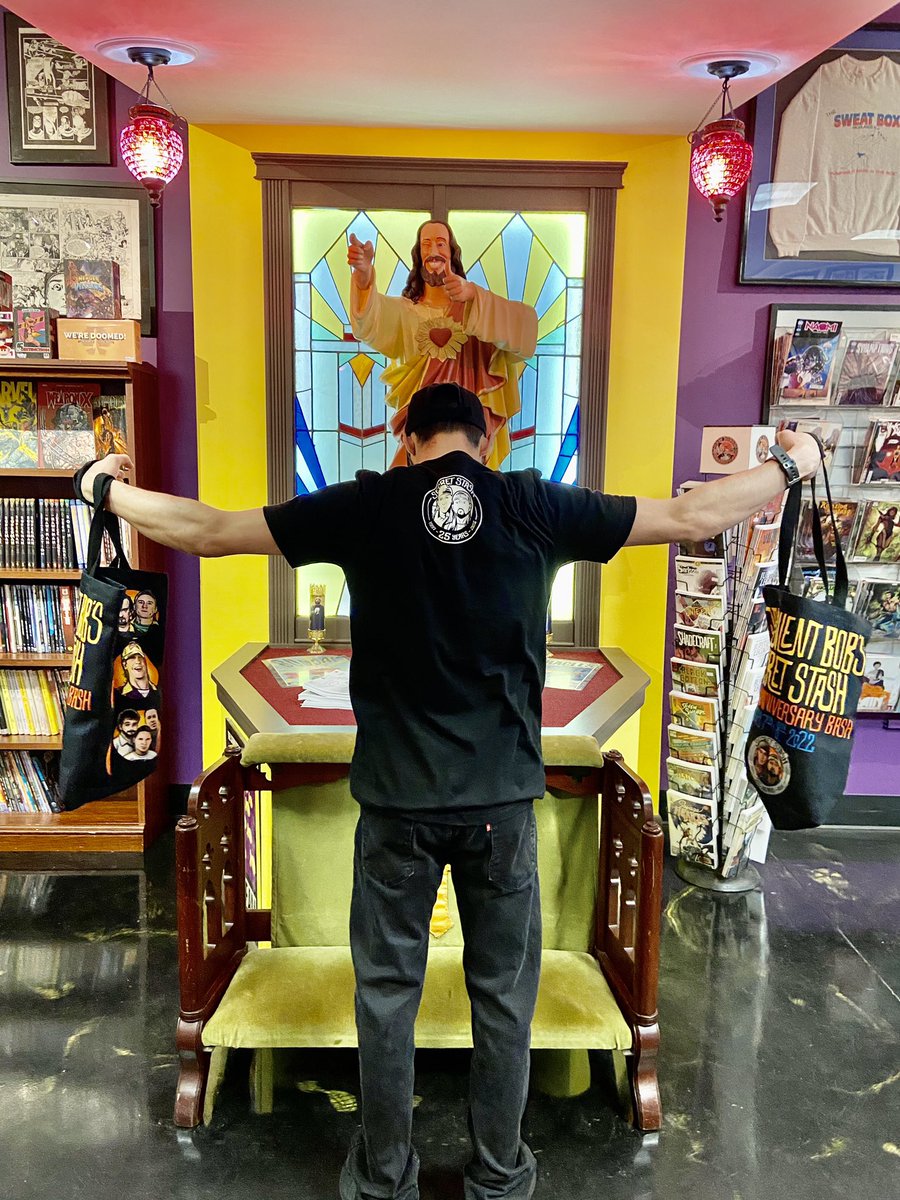 The_SecretStash's tweet photo. AVAILABLE NOW! We’ve got some cool celebratory swag, created as part of the Stash’s Silver Anniversary year Bash, on sale in store &amp; on the Stash’s online storefront: https://t.co/99kZa8Nccy.  Up today: limited edition t-shirt, canvas bag and lanyard. #stashbash #comics https://t.co/vakbwq6FAp