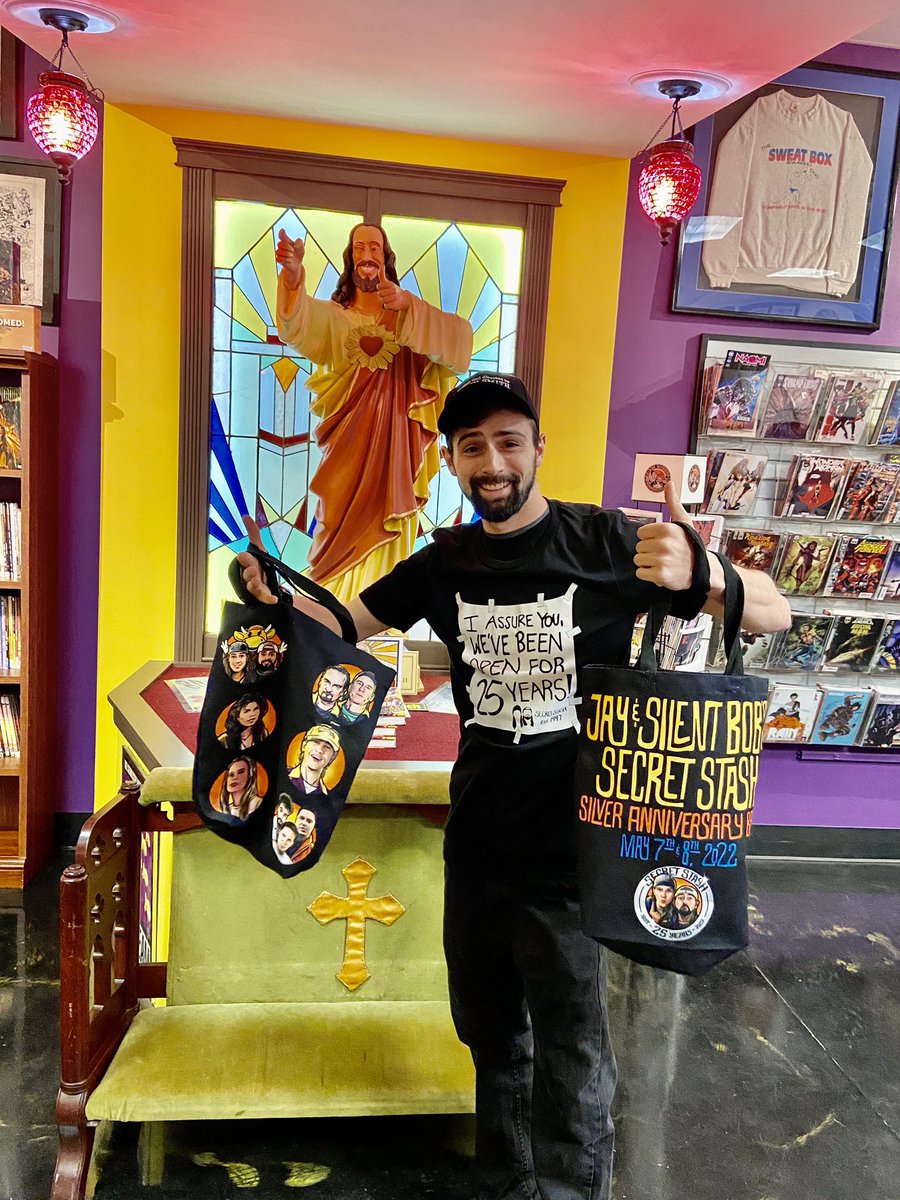 The_SecretStash's tweet photo. AVAILABLE NOW! We’ve got some cool celebratory swag, created as part of the Stash’s Silver Anniversary year Bash, on sale in store &amp; on the Stash’s online storefront: https://t.co/99kZa8Nccy.  Up today: limited edition t-shirt, canvas bag and lanyard. #stashbash #comics https://t.co/vakbwq6FAp