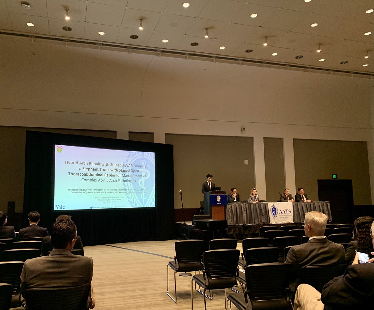 YaleCardiacSurg's tweet photo. Our 4th year medical student @MichaelRShang presenting outcomes of #hybrid #arch repair with staged #TEVAR among the giants of Aortic surgery at #AATS22! @PrashanthVall12 @JElefteriades @RolandAssiMD @MohammadAZafar @AndreaAmabileMD @AATSHQ https://t.co/EUSqamO9uT