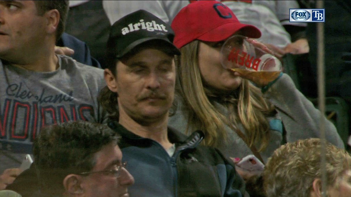 Matthew McConaughey barely awake and wearing a trucker hat that says "alright"