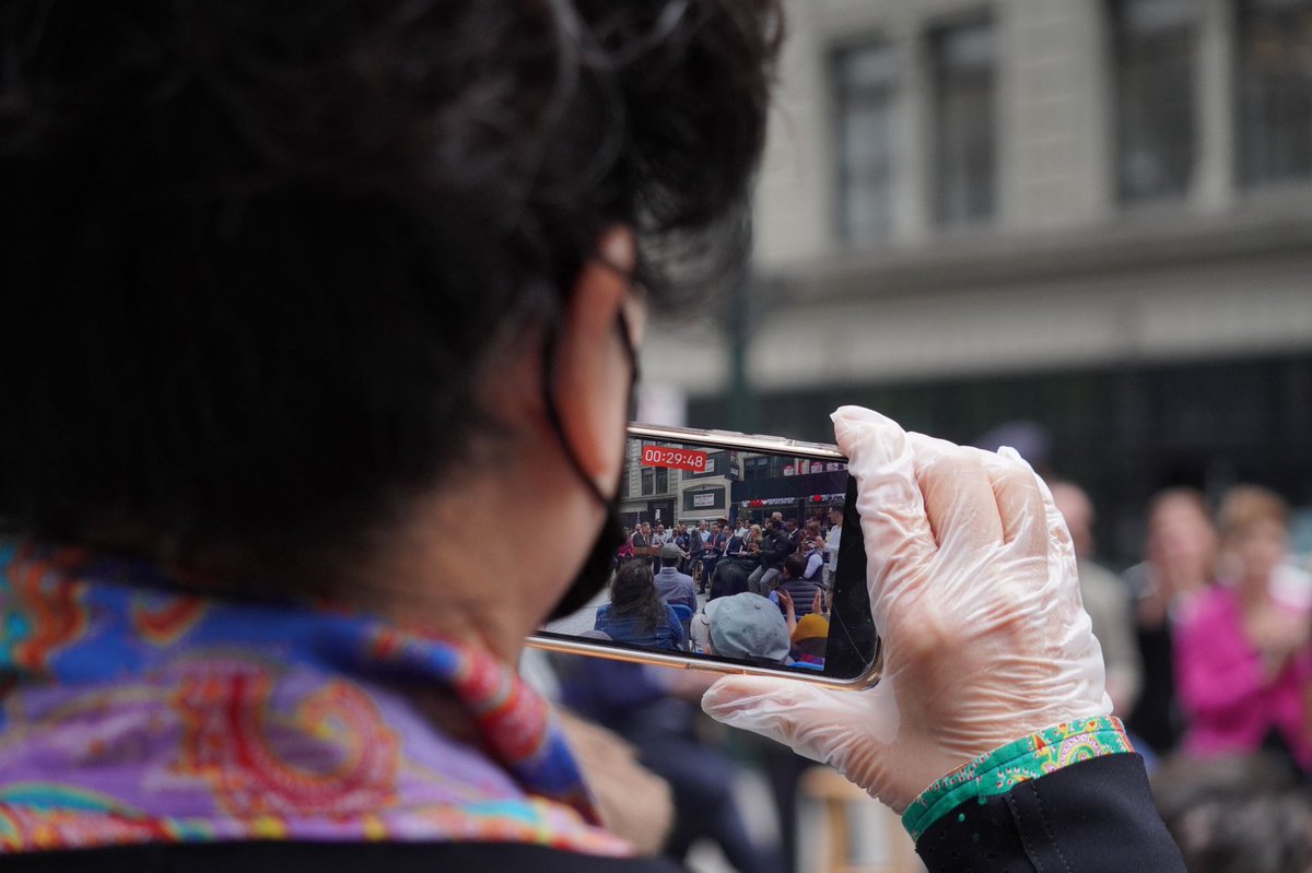 A woman takes a photo of the press conference.
