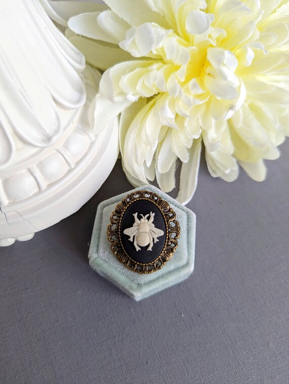 PapillionEra's tweet photo. Bee brooch, Bumble Bee pin, Bee cameo brooch, https://t.co/GZSj2UMVvL #beebrooch #beepin #beecameobrooch #bumblebeejewelry #naturelovergift @etsymktgtool https://t.co/eHPD3A4eJq