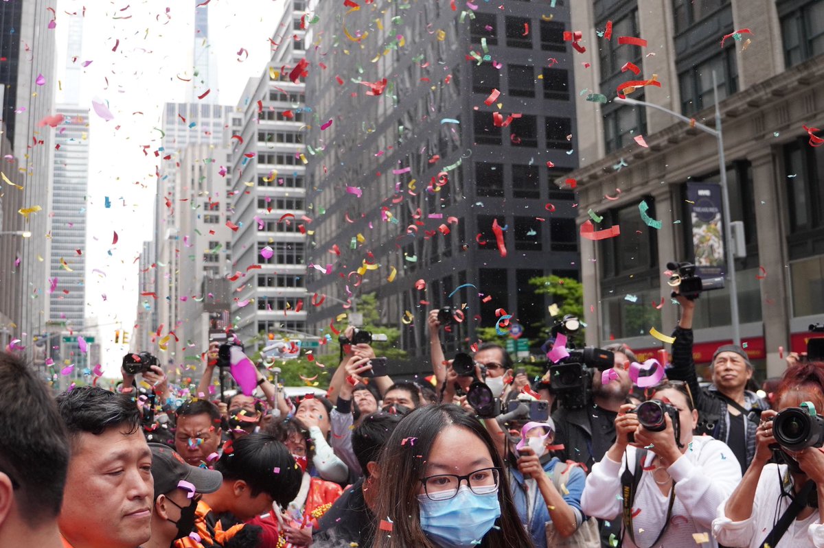 Parade attendees celebrate as confetti falls.